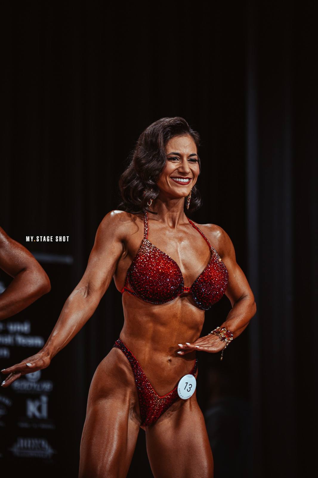 Masters-Athletin in der Frontpose vor dunklem Hintergrund